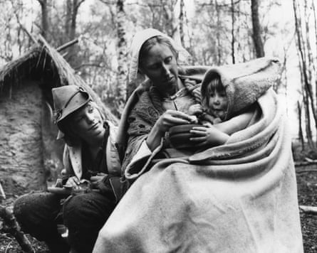 A still from Winstanley (1975) showing a woman and two children in 17th-century period dress.