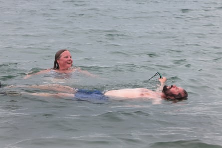 Anna smiles while swimming beside her husband, Jim, floating on his back in the sea