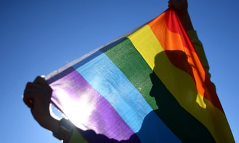 person holds rainbow flag