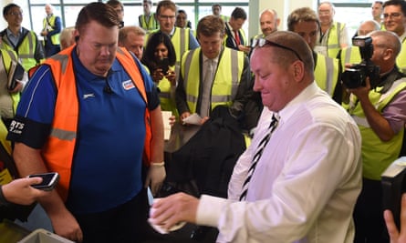 Mike Ashley empties his pockets of bank notes during a mock search at the Sports Direct warehouse in Shirebrook in 2016.