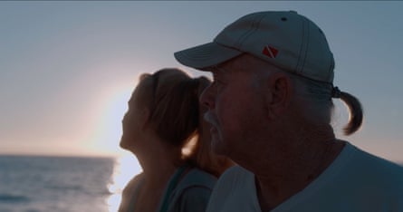 a man and a woman look out to sea