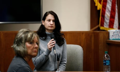 A young woman holds a microphone in a courtroom.
