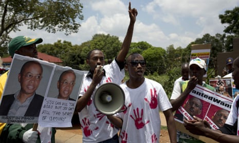 Opposition activists with posters criticising Rwandan president Paul Kagame after the death of Patrick Karegeya in South Africa.