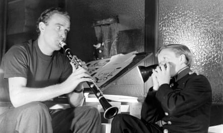 Wally Fawkes performing a duet on his clarinet with a young harmonica player in 1951.