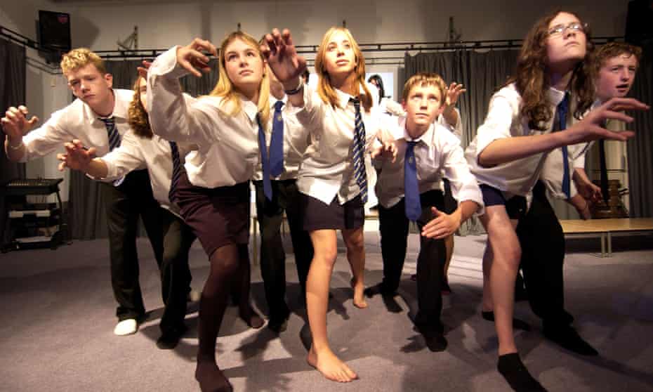 Teenagers in school uniforms in a drama lesson