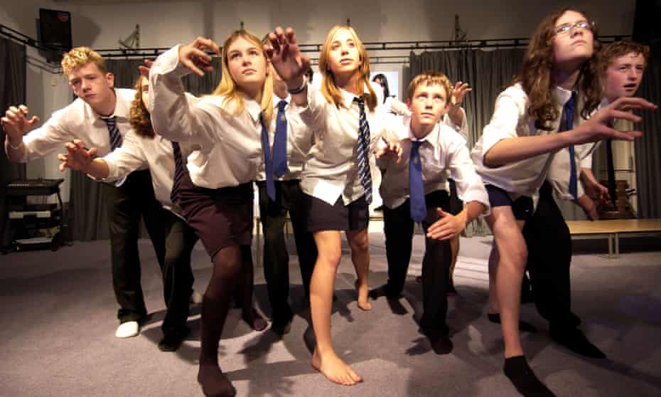 Teenagers in school uniforms in a drama class