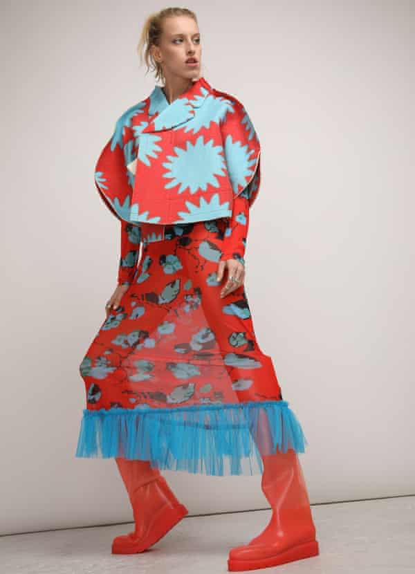 A model wearing a bright blue and red patterned Molly Goddard dress and Comme des Garçons jacket from rental company Higher Studio
