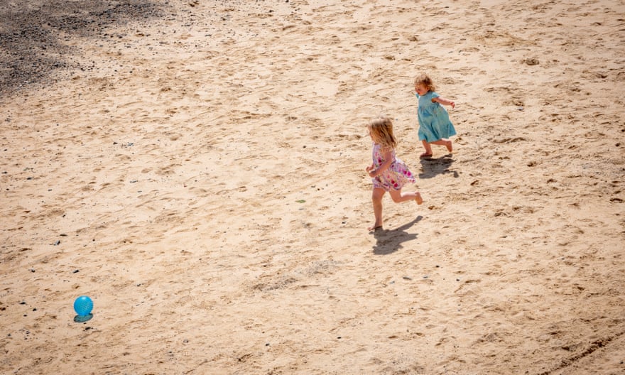 Children play on the beach in St Ives for British summer day feature