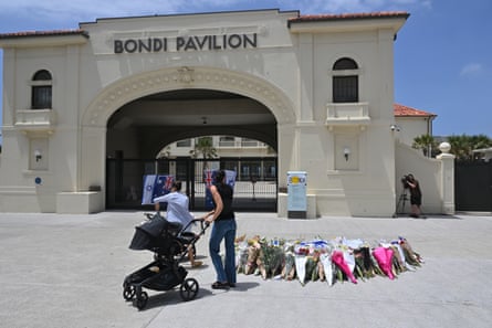 Mourners place flowers at a makeshift memorial at Bondi Beach.