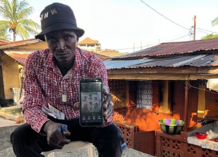 Daddy Hassan Kamara shows photographs on his phone of the family members he lost in the Ebola outbreak.