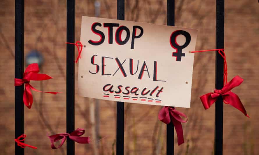 Protest poster reading Stop Sexual Assault and ribbons on the railings of a girls’ school.