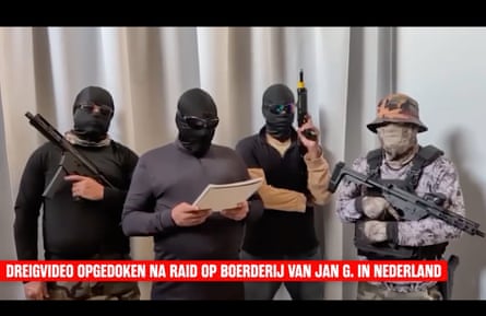 Four masked men in a video, three hold guns while one reads from a pad of paper