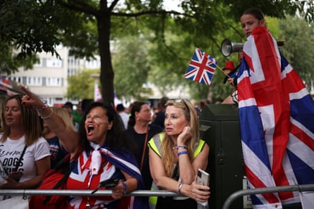 A group of protesters wearing Union Jacks and holding flags