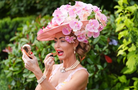 A racegoer puts lipstick connected astatine Royal Ascot.