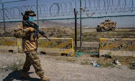 Taliban fighters secure the outer perimeter, in plain sight of the American forces that control the Hamid Karzai International Airport in Kabul, Afghanistan.