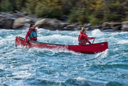 Two people in a red canoe on the Tatchun River, Yukon.
