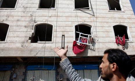 Yemen Sanaa Airstrikes - 11 Nov 2021<br>Mandatory Credit: Photo by Xinhua/REX/Shutterstock (12598913d) A local resident points at the broken windows of a building that was damaged during an airstrike in a neighborhood of Sanaa, Yemen, on Nov. 11, 2021. Warplanes of the Saudi-led coalition launched multiple airstrikes on military camps controlled by the Houthi militia in and around Yemen's capital Sanaa early Thursday morning, Houthi-run al-Masirah TV reported. Yemen Sanaa Airstrikes - 11 Nov 2021