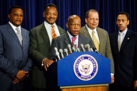 four men stand behind John Lewis at a lectern