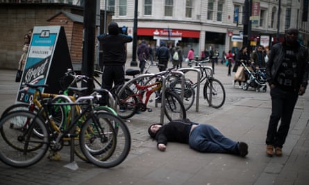 A man who has taken spice lies flat out on the pavement on Piccadilly Gardens, Manchester