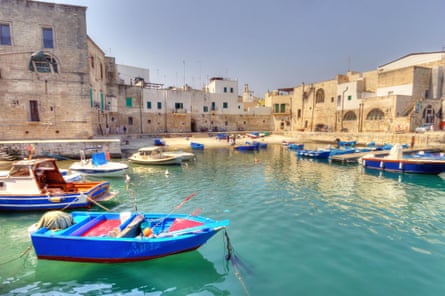 Small boats docked in the harbour in an old Italian town.