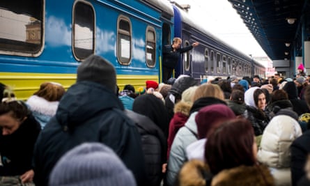 People desperately try to board trains headed west at Kyiv-Pasazhyrskyi central station