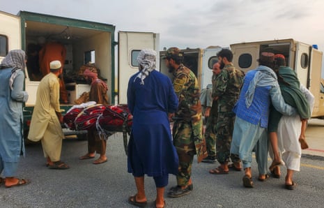 Los soldados y civiles talibanes llevan víctimas de terremotos a una ambulancia en un aeropuerto de Jalalabad.