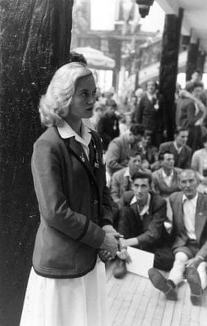 A member of staff at a Butlin’s holiday camp, Skegness, is admired by male holiday makers, 1955