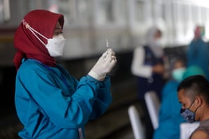 A health worker prepares a dose of Sinovac during a mass vaccination drive at Bogor train station, Indonesia.