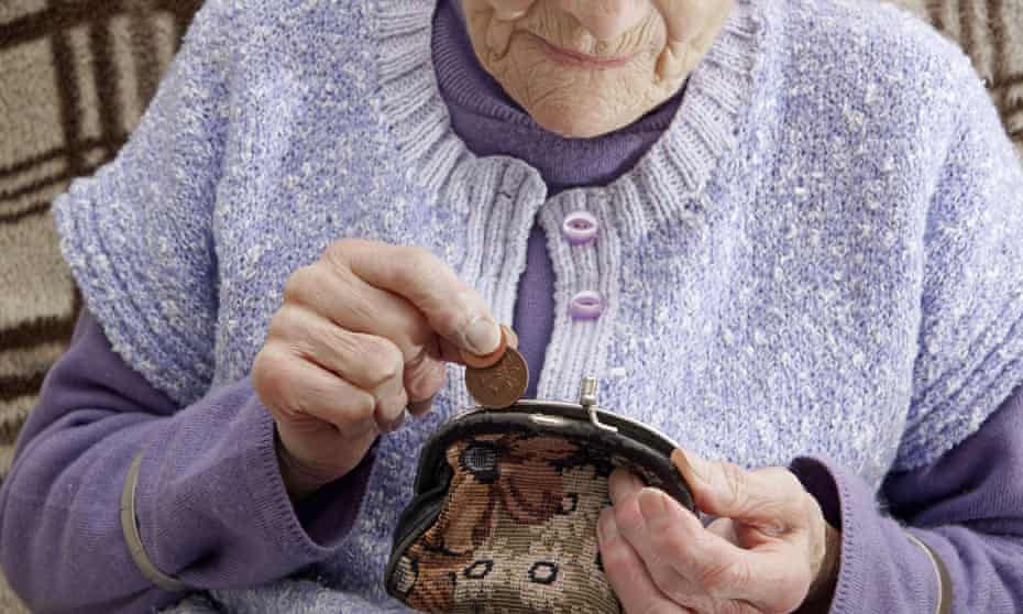 An older woman taking small change out of her purse.
