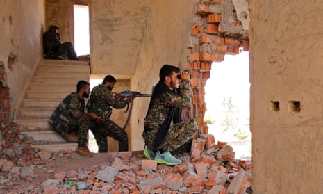 YPG fighters take up positions inside a damaged building