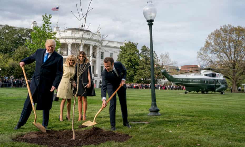 Melania Trump and Brigitte Macron watch as President Donald Trump and French President Emmanuel Macron participate in a tree planting ceremony on the South Lawn of the White House in April 2018.