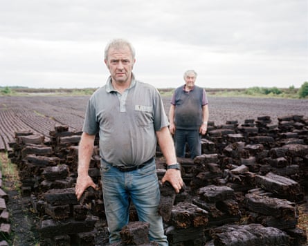 Men cutting turf in a field