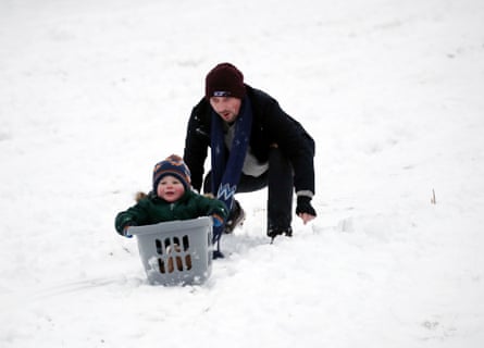 A man and a boy sledge on a snowy hill