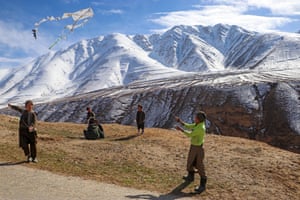 Boys fly kites on a hilltop