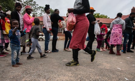 People queue for food parcels at an animal welfare clinic in Durban Deep, Johannesburg