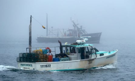 Two fishing boats in the fog at sea