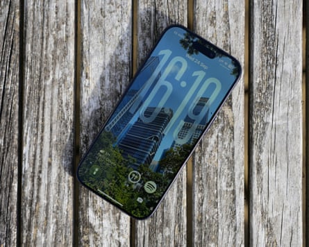 The lock screen of an iPhone 17 Pro lying on a table outdoors.
