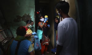 A health worker screens people for COVID-19 symptoms at Dharavi,