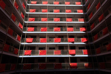 Chinese national flags hang from balconies on every floor of a housing estate