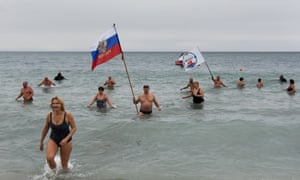 Crimean people wave a Russian national flag