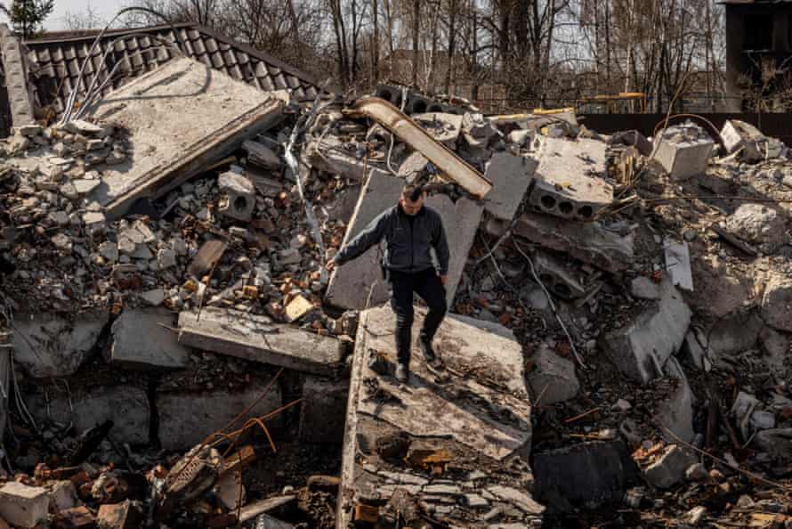 A policeman walks among the rubble of a destroyed house in Bohdanivka village, northeast of Kyiv.