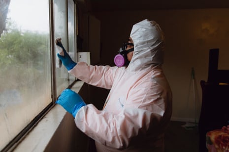 a person in a hazmat suit cleans an apartment