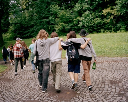 Children walk along a path with arms around one another