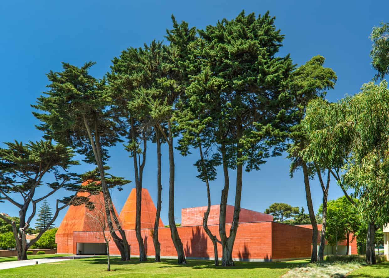 Red brick pyramidal buildings with tall trees in front