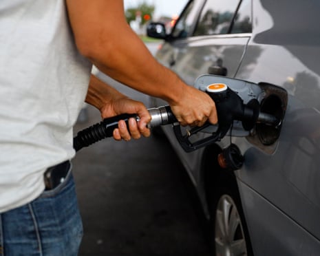 A man fills his car with fuel at a petrol station