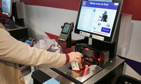 A customer uses a self-service checkout at a supermarket