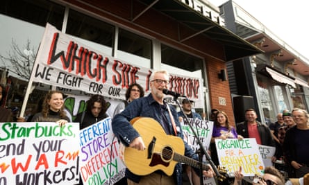 بیلی براگ خواننده برای اعضای اعتصابی اتحادیه کارگران استارباکس در خارج از مکان استارباکس در بوفالو، نیویورک، در 12 اکتبر 2022 اجرا می کند.