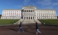 People walk in front of the Stormont assembly building.