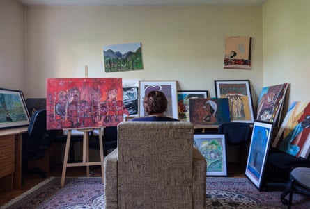 Drita sits in a chair surrounded by pictures in Medica Kosova’s art therapy room
