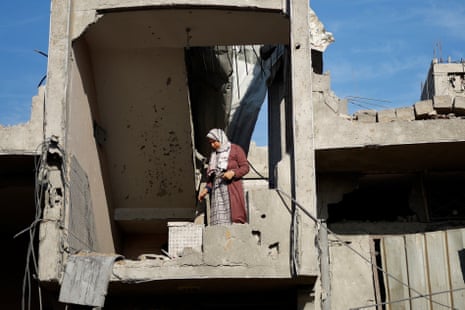 A Palestinian woman stands inside a damaged house at the site of Israeli strikes in Rafah.